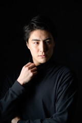 Fototapeta premium 黒背景でクールな表情の日本人男性