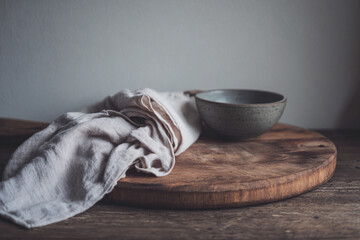 Realistic still life of wooden cutting board with cloth and bowl on rustic table Generative AI