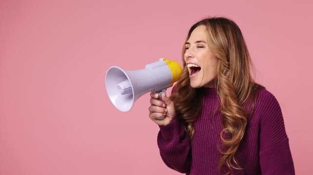 Surprised shocked excited fun young woman she wear purple knitted sweater casual clothes hold in hand megaphone scream announces discounts sale Hurry up isolated on plain pastel light pink background