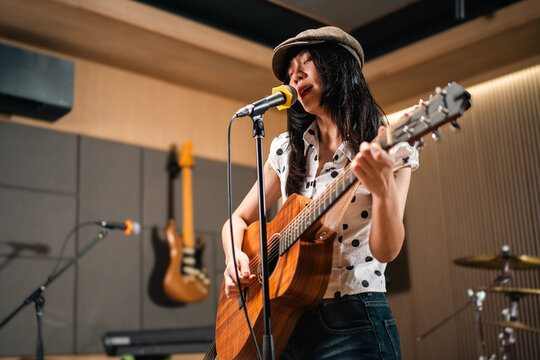 Young asian music group Band members rehearse with instruments guitar bass drum. Teamwork music band practice in studio prepire perform. Vocalist and band