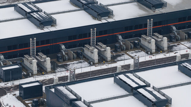 Aerial view of Agriport datacenters blanketed in snow, the geometric architecture stark against the white landscape, Middenmeer, North Holland, Netherlands.