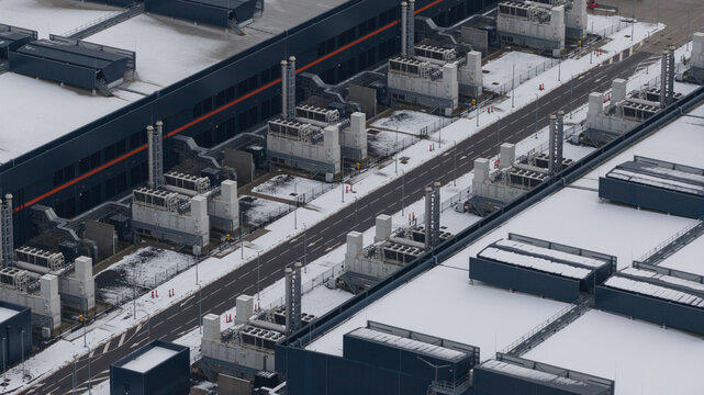 Aerial view of a landscape punctuated by the stark geometry of Agriport datacenters, dusted with winter's touch, Middenmeer, North Holland, Netherlands.