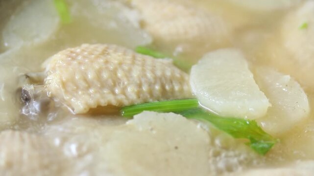 Boiling clear soup with daikon radish and chicken wings in a pot. Healthy food