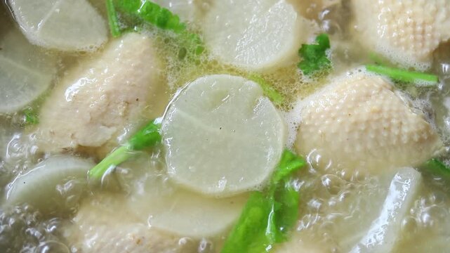 Boiling clear soup with daikon radish and chicken wings in a pot. Healthy food