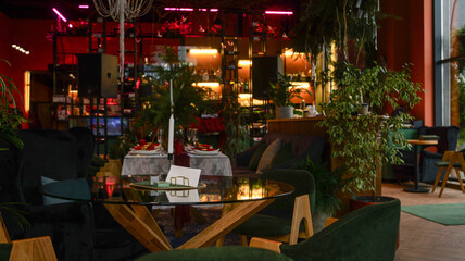 Elegant restaurant interior with lush greenery and candlelit dining tables