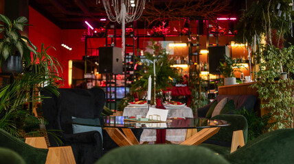 Elegant restaurant interior with lush greenery and festive table setting