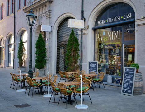 Die Aussenfassade des Feinkostgesch&auml;fts Paganini mit bestuhlter Terrasse in der Augsburger Altstadt neben der Goldschmiede Werner