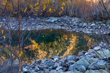 Reflection of mountains in water of Lake Baduk in a gorge on Dombai