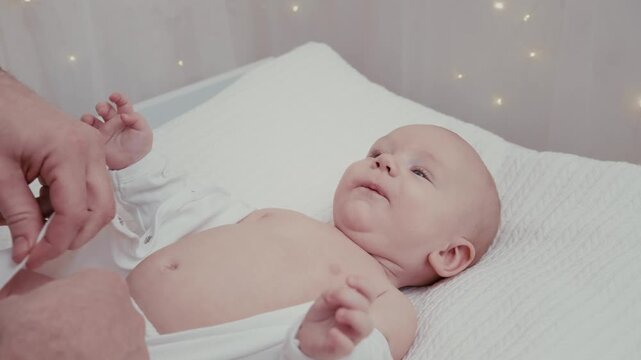 Loving father dressing his newborn baby lying on a changing table, a tender moment showing parental care, family bonding, and the challenges and joys of raising a child at home