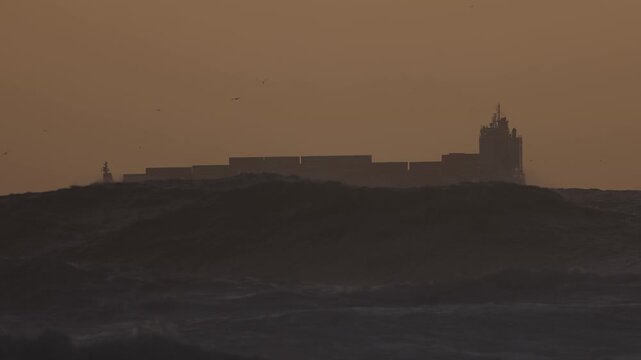 Cargo ship with containers on the ocean during a storm