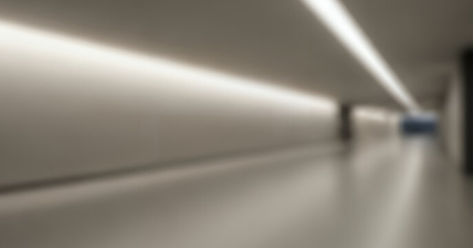 Soft focus view of a long modern corridor with repeating columns, neutral tones, and polished flooring that creates strong symmetry and depth for abstract architectural or corporate background use.