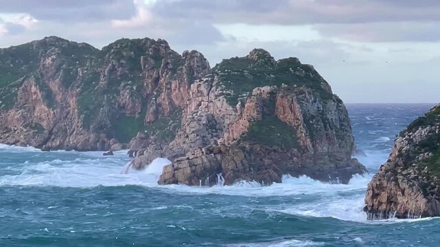 A medium shot of two islands and the channel between them in a stormy Mediterranean Sea. 0.9x slow motion. Mallorca, Spain.
