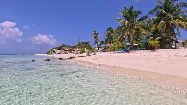 Empty white sand beach in Ukulhas Maldives with palm trees and turquoise water