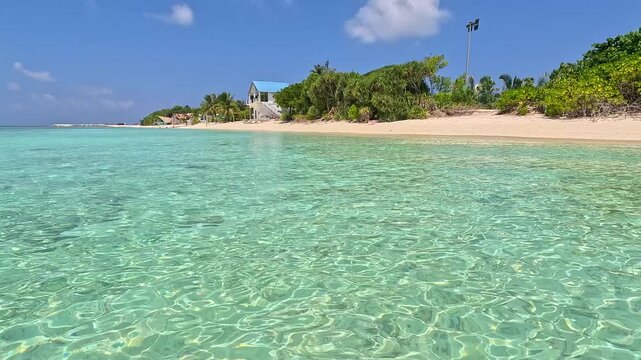 Empty white sand beach in Ukulhas Maldives with palm trees and turquoise water