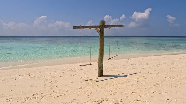 Empty white sand beach in Ukulhas Maldives with palm trees swings and turquoise water