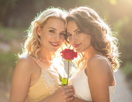 Lesbisches Paar mit roter Rose zum Valentinstag