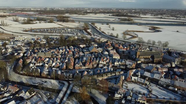 Aerial footage of a snow covered  Dutch town of Hattem in winter time. 