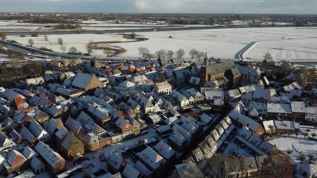 Aerial footage of a snow covered  Dutch town of Hattem in winter time. 