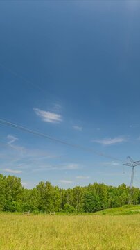 A power transmission line PTL support pointing upward against a blue sky.