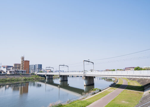 晴れた日の川と線路橋、都市近郊の風景