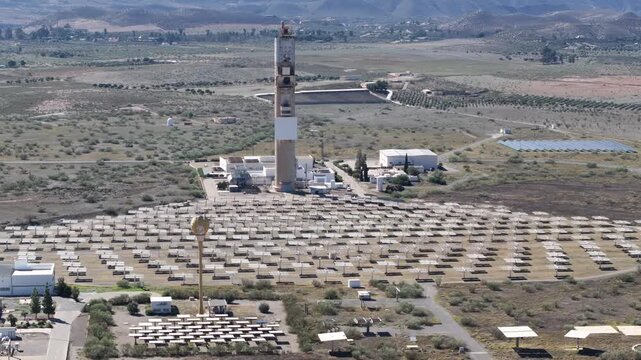 Drone aerial of concentrated solar power tower with mirror array and desert plain near Almeria Spain sustainable energy technology