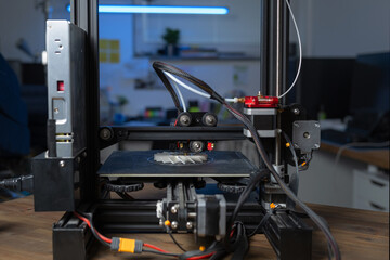 3D printer produces plastic prototype using additive manufacturing in a clean workspace. Focus on automation and engineering processes.