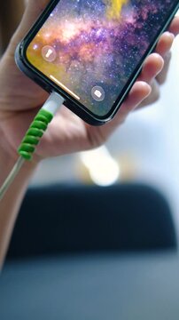 Close Up Hand Connecting Charging Cable to Smartphone.