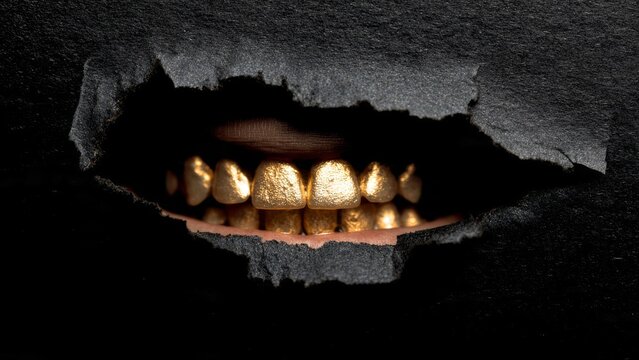 Gold Teeth Revealed Through Torn Black Paper - Dental Bling

