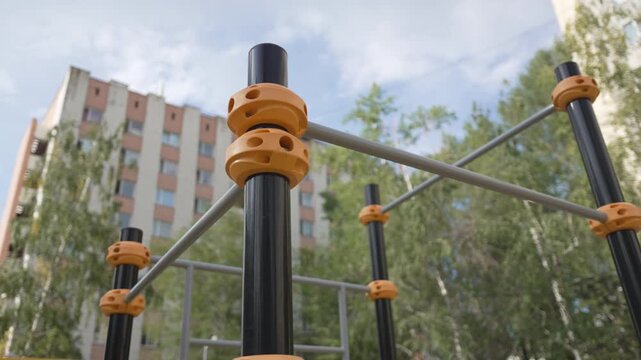 Outdoor sports ground equipped with bars and parallel rails for bodyweight training. Functional open space supports active urban lifestyle