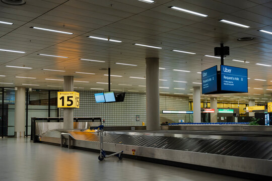 January 23, 2026, Amsterdam, Netherlands - Empty baggage claim area at Schiphol Airport with Uber signs