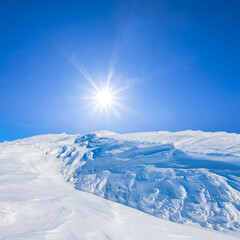 mountain ridge in a snow at the cold sunny winter day, seasonal travel scene