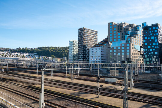 Oslo Norway railway tracks and infrastructure near modern buildings with urban skyline highlighting transport network in sunny daylight