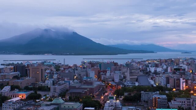 Kagoshima, Japan. View of mountain Sakurajima an active volcano. Aerial view of Kagoshima city in Japan at sunrise. Time-lapse with volcano eruption in the morning