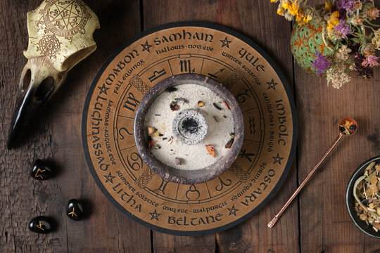 Preparation for a Wicca incense ritual with herbs, resins and mystical symbols