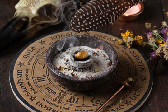 Close-up of a Wicca incense ritual &ndash; spreading sacred smoke with a feather