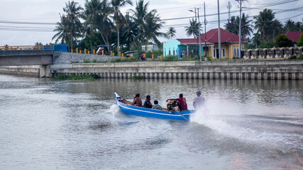 Fototapeta premium Motorboat Travels Through a Canal