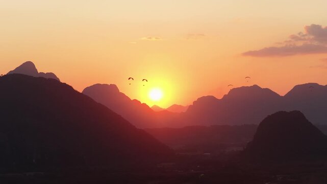 Aerial close up of hot air balloon festival during romantic sunrise over mountains of Vang Vieng, Laos, famous tourist destination