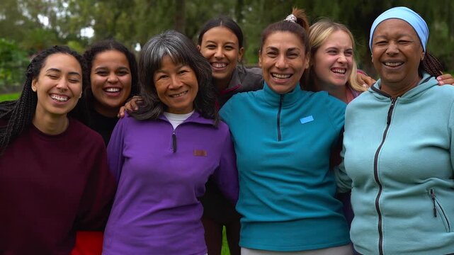 International women circle smiling on camera outdoor - Happy group of multi generational people hugging each other - Humanity, female community and support concept