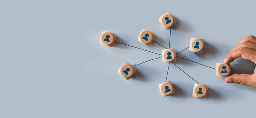 Organizational network structure with connected people icons on wooden blocks, showing team...