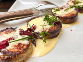 Appetizing lamb medallions from tender round pieces of tenderloin with creamy sauce in one of the...