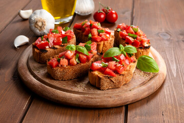 Bruschette con pomodoro fresco, erbe aromatiche e olio extravergine di oliva, spuntino italiano 