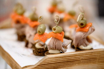 Obraz premium Assorted meat appetizers on black bread and desserts on a served table