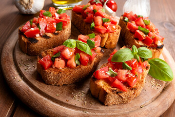 Bruschette con pomodoro fresco, erbe aromatiche e olio extravergine di oliva, spuntino italiano 