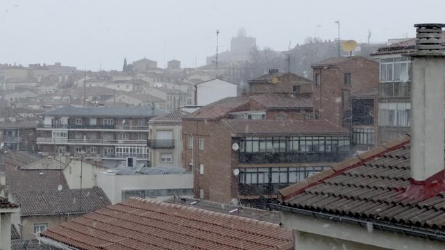 Heavy snow falls on a silent residential street in &Aacute;vila at night, covering pavements, parked cars and trees, while soft street lighting adds a peaceful, wintry atmosphere to the urban landscape.