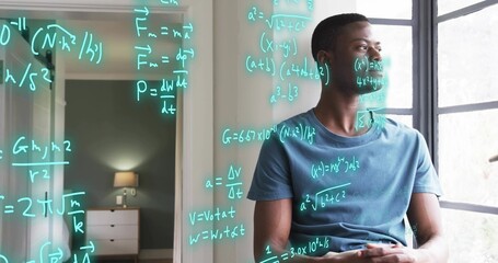 Studying man in blue tee sitting by window, with wireless earbud, viewing cyan equations on glass © vectorfusionart