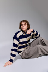 Stylish teenager showcases modern fashion with an active pose in a creative studio setting