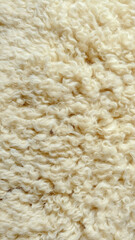 Soft white lamb wool background showing dense curly sheep hair structure