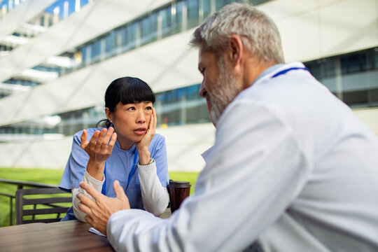 Nurse and doctor discussing concerns outside hospital
