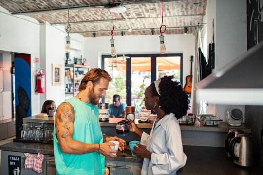 Coworkers making coffee in a shared loft kitchen