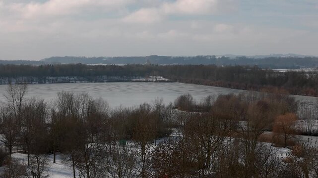 Winter landscape near Pocking Bavaria seen from observation tower with snowy fields and trees under cloudy sky